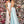 Clarisse 8105 is a long a-line prom dress with a low scoop neckline, open lace up back, side pockets, and a cross over high slit skirt. Shown in Champagne and Seafoam.