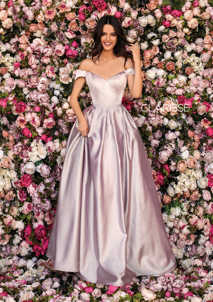 Clarisse 8010 is an off the shoulder ball gown prom dress with a self-fabric belt detail, roomy side pockets, and lace up back, made in shimmering mikado fabric.